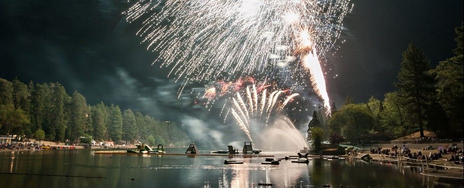Fireworks display over a lake at night.