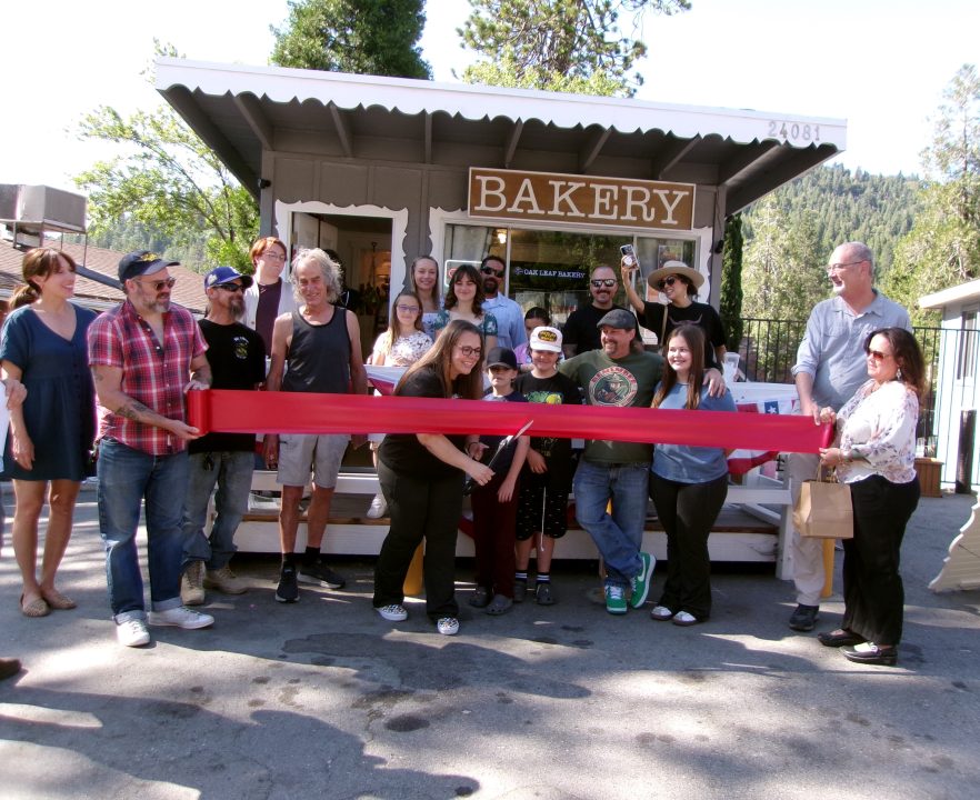 Group at bakery ribbon cutting ceremony outdoors.