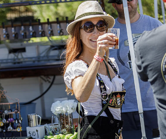 Woman enjoying beer festival outdoors.