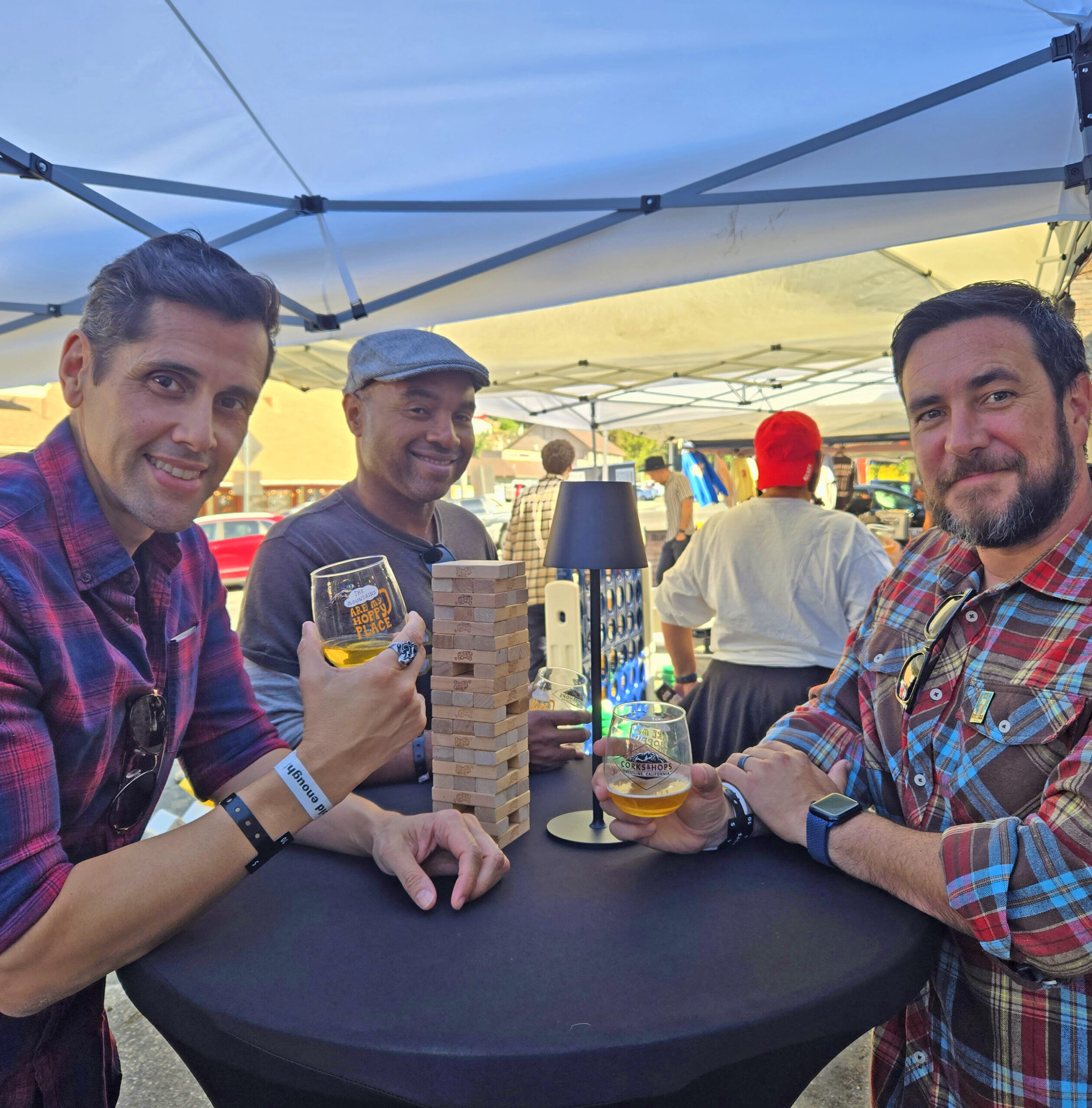 Adrianne, Lisa, Julia, Melissa and Adrianna from Glendora and Orange County enjoyed last year’s Brewfest at Tavern Bay Beach Club so much they couldn’t resist attending this year’s event. (Photos by Douglas W. Motley) Three men enjoying drinks and playing Jenga outdoors.