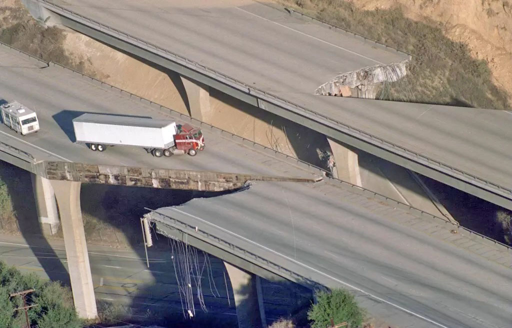 Truck on collapsed highway bridge after earthquake damage
