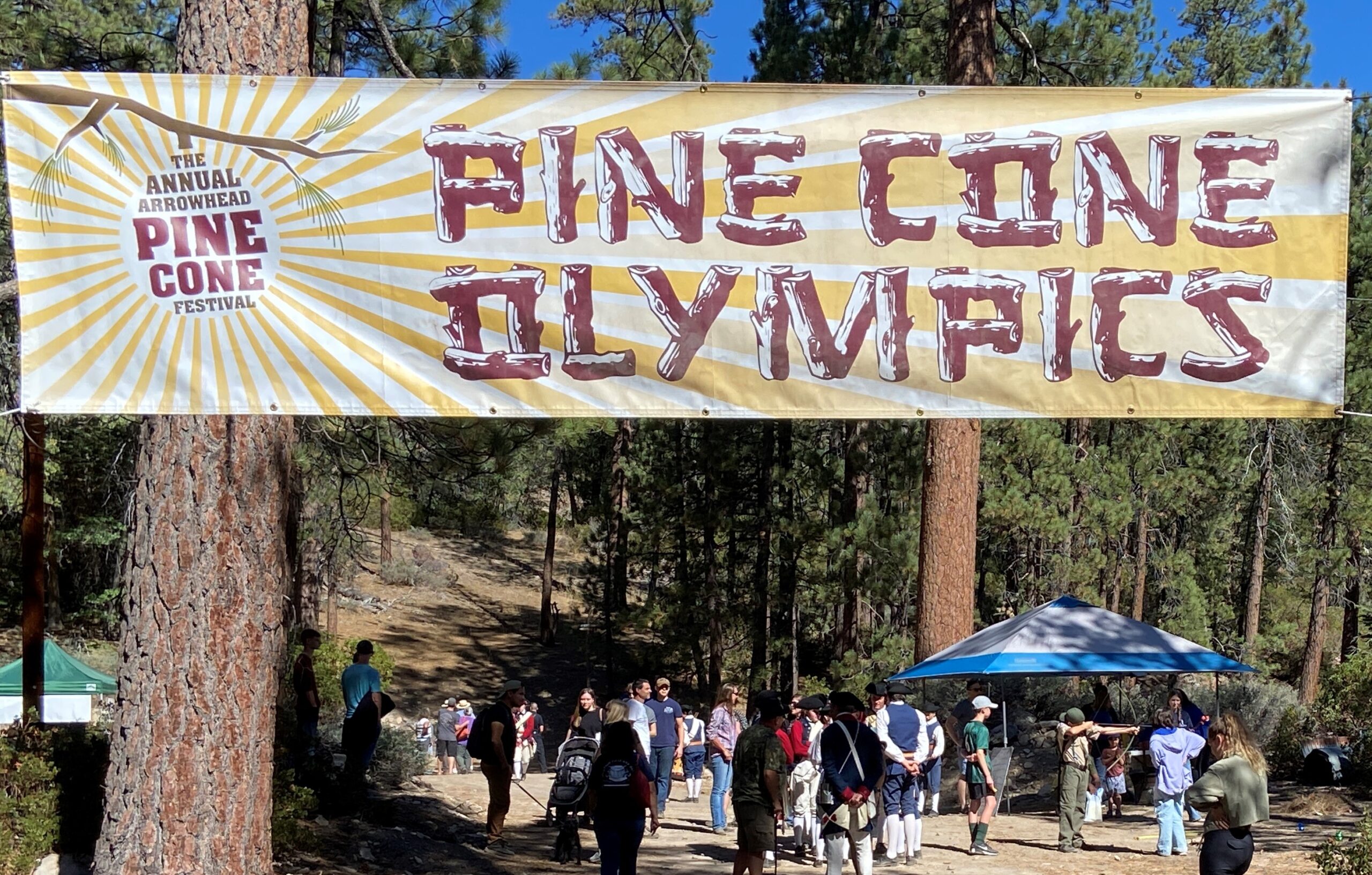 Adrianne, Lisa, Julia, Melissa and Adrianna from Glendora and Orange County enjoyed last year’s Brewfest at Tavern Bay Beach Club so much they couldn’t resist attending this year’s event. (Photos by Douglas W. Motley) Pine Cone Olympics festival banner in forest setting.