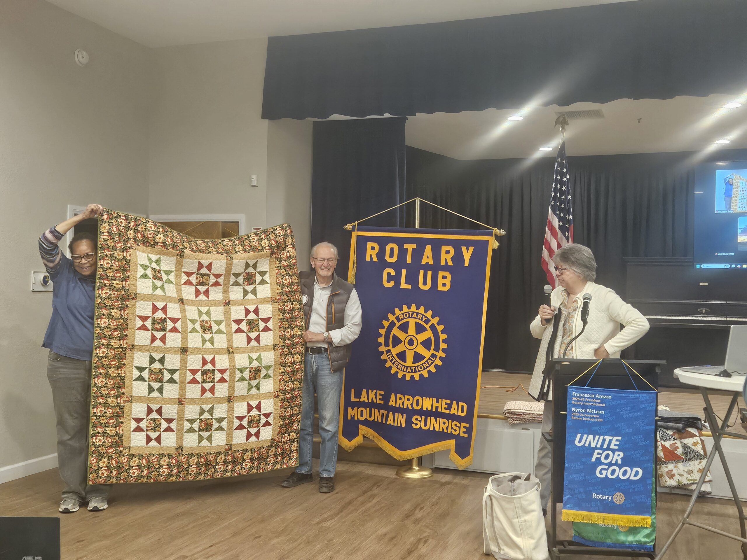 Rotary Club meeting showcasing a colorful quilt.