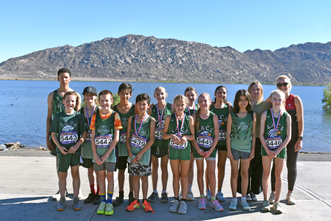 Junior cross country team posing by lake.