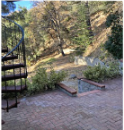 Brick patio with spiral staircase and forest view
