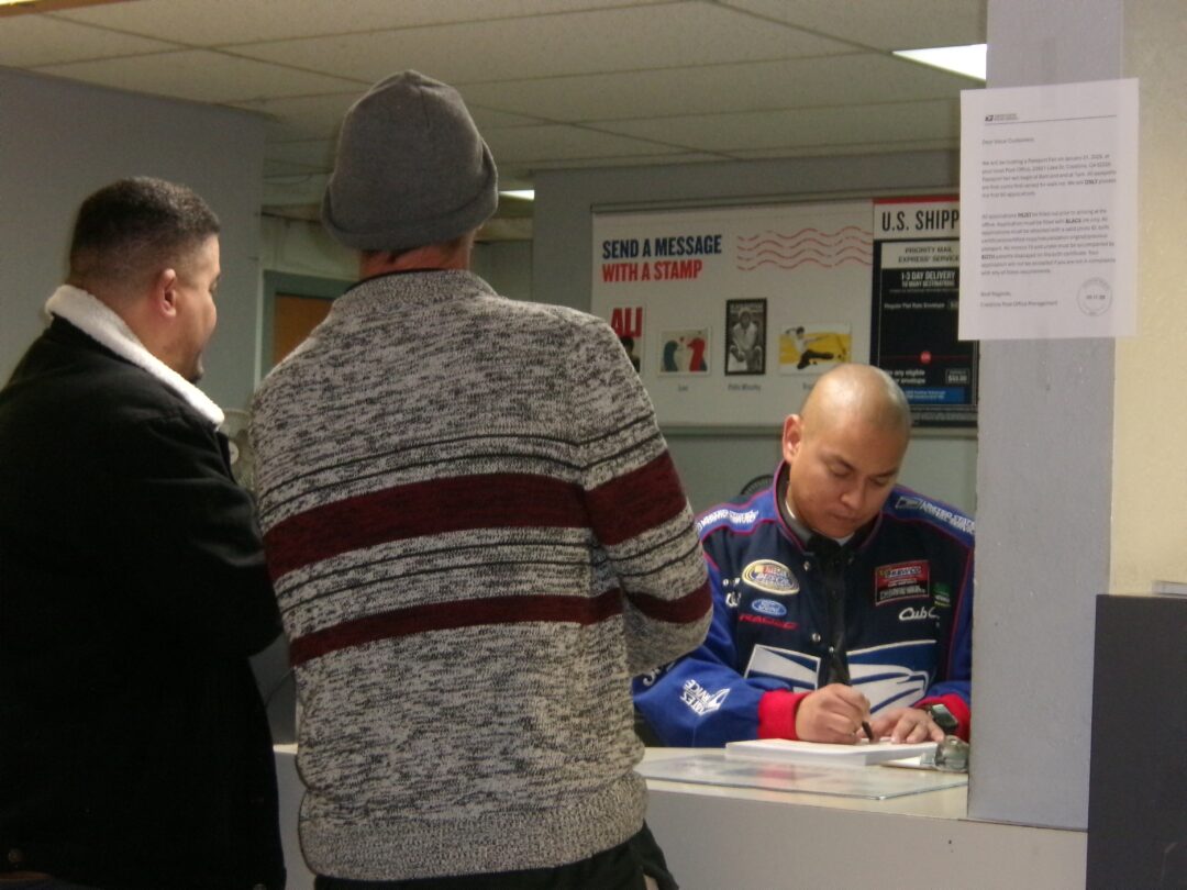 Applicants during passport Saturday at the front window with Luis Cervantes helping them properly fill out the paperwork. (Photo by Rhea-Frances Tetley)