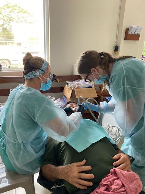 Nolan Massey assists dental hygienist Shellie Boydston.