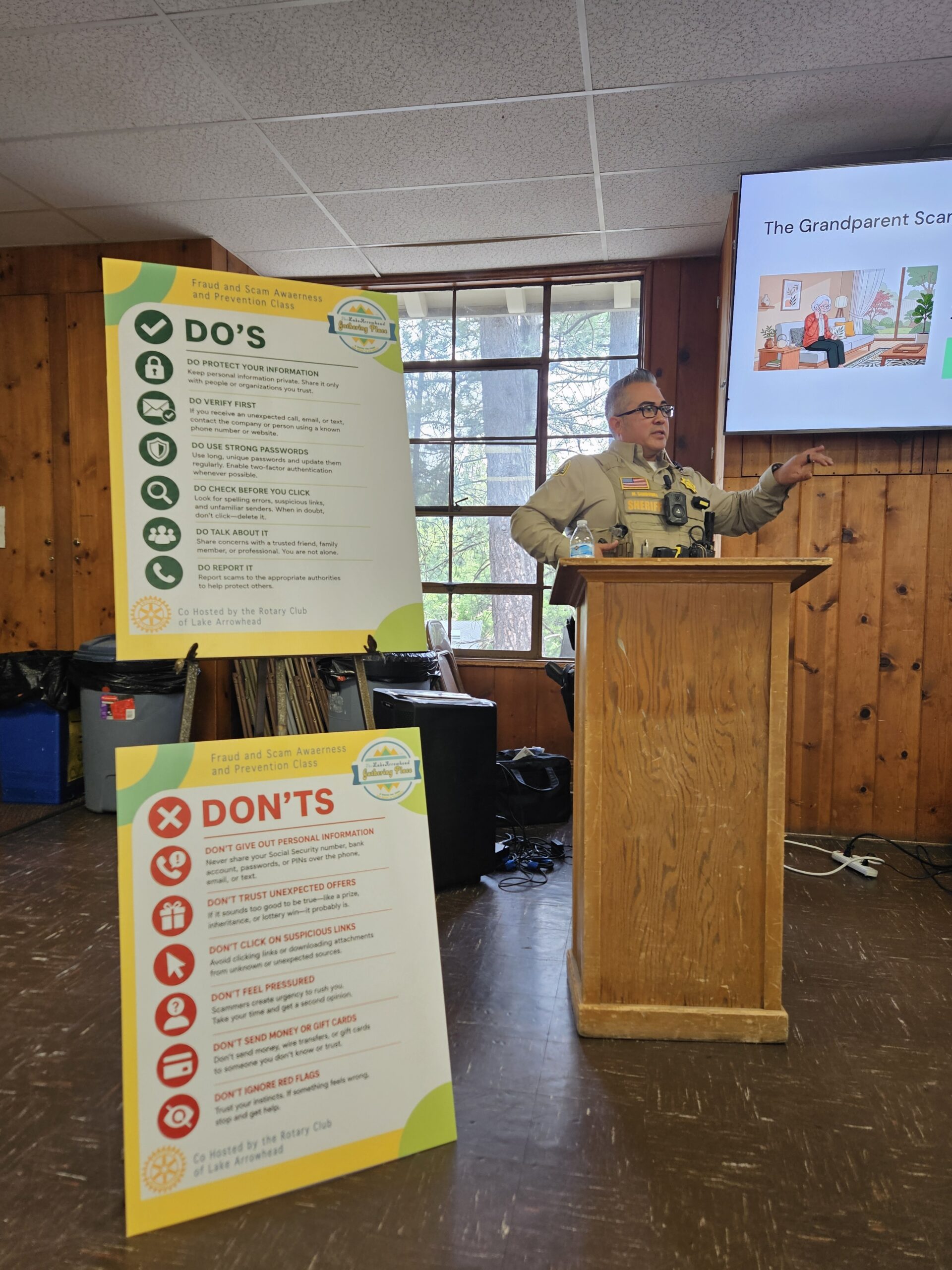 Deputy Mark Sandoval urges everyone to take a breath before reacting to what could be a scam. Note the boards with Dos and Don’ts. (Photo by Mary-Justine Lanyon)