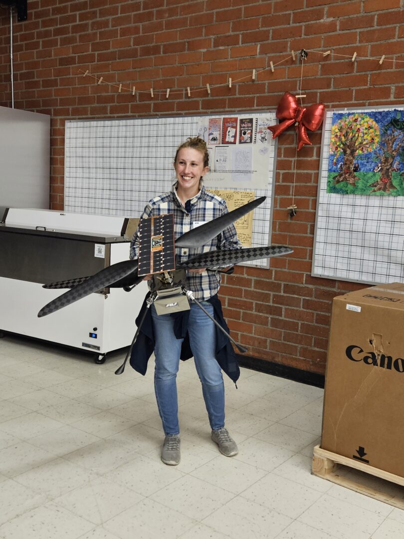 Rim High grad Paulina Ridland holding Terry, a replica of Ingenuity, the helicopter currently on Mars. (Photos by Mary-Justine Lanyon)