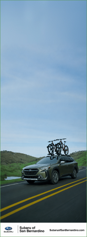 Subaru SUV with bikes driving through green hills